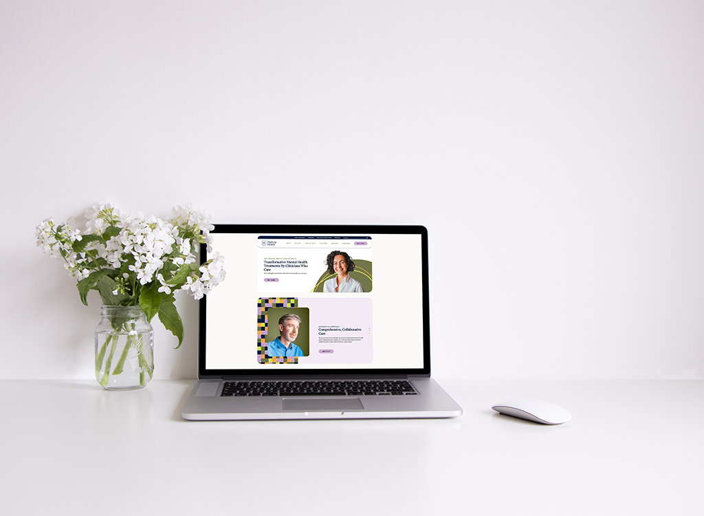 Laptop displaying a mental health website with a floral arrangement beside it, emphasizing digital wellness and online therapy resources.