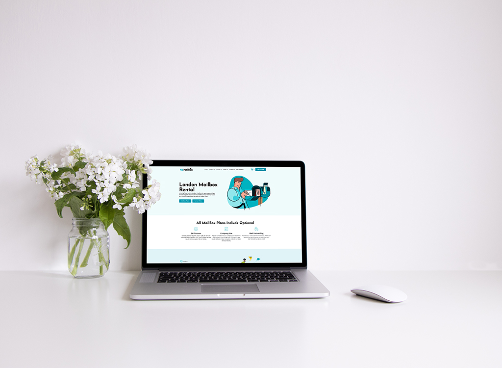 Laptop displaying a website for London mailbox rental services, featuring a clean design and floral arrangement in a glass vase on a minimalistic desk.