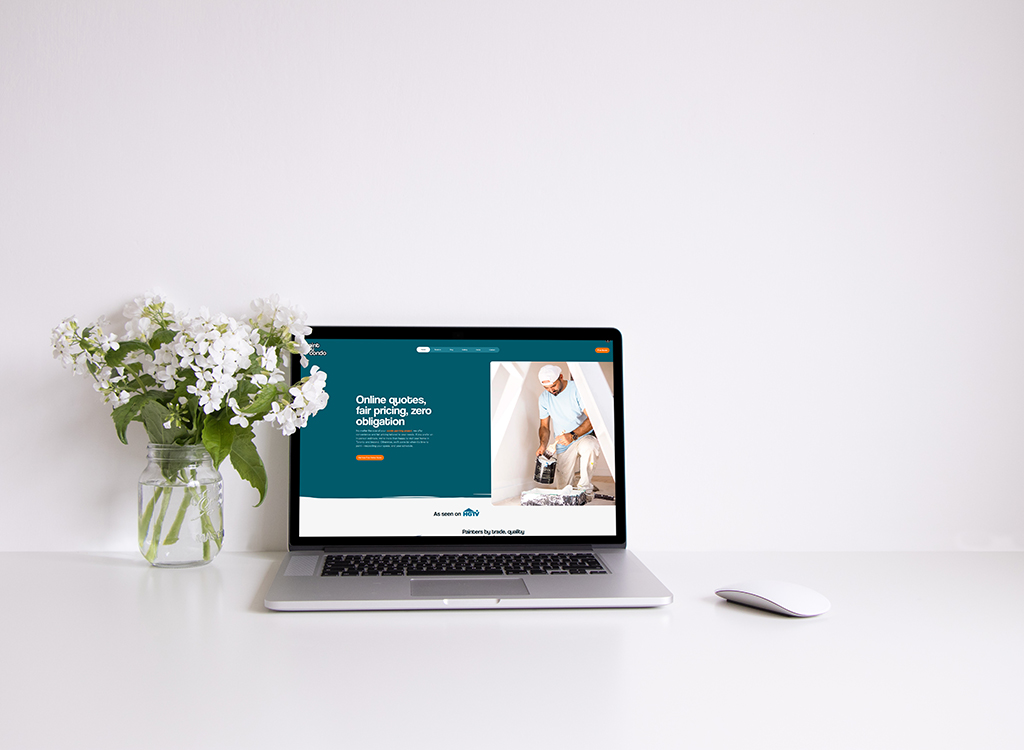 Laptop displaying a website offering online quotes and fair pricing for home services, with a vase of white flowers beside it on a clean desk.