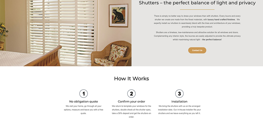 Interior view of a room featuring elegant white shutters on a window, complemented by a cozy seating area with patterned cushions and a decorative cat artwork on the wall, highlighting the balance of natural light and privacy in home design.